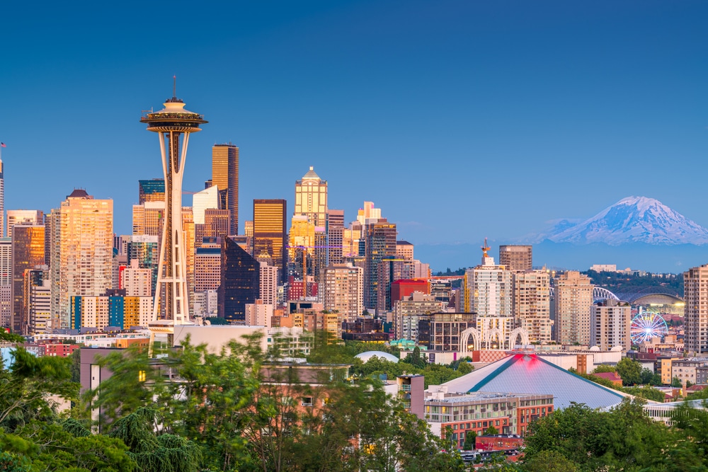 Seattle city skyline at dusk showing space needle and mt rainier